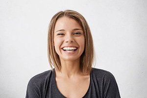 woman smiling after practicing dental implant care in Edmonton