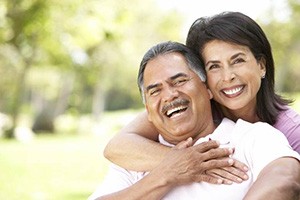 Smiling couple with dental implants in Edmonton