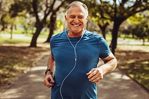 Healthy man with dental implants in Edmonton jogging