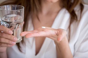 Closeup of patient holding oral conscious sedation medication in Edmonton 